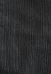 Tissu noir avec une texture tissée, présentant un motif diagonal subtil. Le matériau semble durable et lisse.