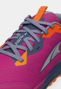 Κοντινή λήψη ενός ροζ και πορτοκαλί παπουτσιού τρεξίματος με γκρι κορδόνια, επενδεδυμένο περιλαίμιο και το λογότυπο "Altra" στο πλάι και στη γλώσσα.