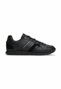 Μαύρο χαμηλό sneaker Tommy Hilfiger με κορδόνια μπροστά, υφασμάτινες επιφάνειες και λογότυπο της μάρκας στο πλάι σε λευκό φόντο.