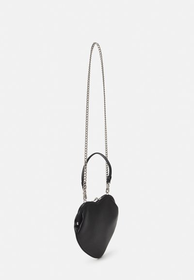 Black heart-shaped handbag with a textured finish, featuring a chain strap and a small top handle. Zip closure accentuates design detail.