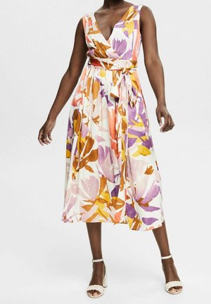 Robe fleurie à décolleté en V profond, sans manches, avec une silhouette en ligne A. Présente des motifs orange, violet et rose sur un fond clair.