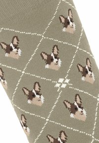 Zielone skarpetki o teksturowanym splocie mają diamentowy wzór z brązowymi i kremowymi psimi twarzami, otoczone białymi liniami.