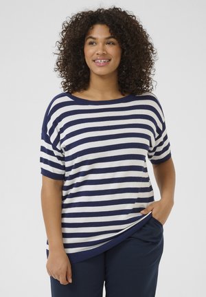 Striped knit top with navy and white horizontal lines, relaxed fit, boat neck, and short sleeves; paired with dark trousers.