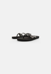 Black flip-flops with a textured sole, featuring a woven black and white check-patterned strap. Minimalist design with a simple silhouette.