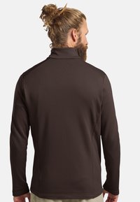 Pull à manches longues marron avec col montant, en tissu texturé et coutures plates, vu de dos, montrant une coupe ajustée.