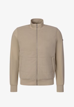 Beige vetoketjullinen takki, jossa on tikattu etupaneeli, yksiväriset pitkät hihat, resoriset hihansuut ja korkeahko kaulus.
