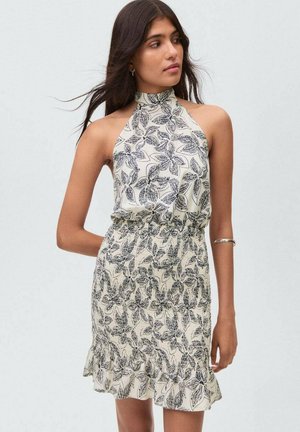 Halterneck jurk in crème met zwart loofprint, gerimpelde zoom, aansluitende taille en lichte stof, geschik voor warm weer.