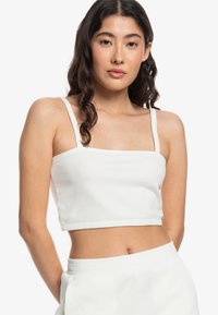 Hvid, ribbet crop-top med firkantet udskæring og tynde stropper, der har en tætsiddende silhuet og en subtil tekstur.