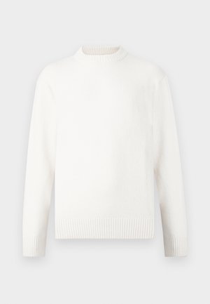 Cremefarvet sweater med en høj ribbet halsudskæring, lange ærmer og ribbede manchetter. Stoffet ser blødt og tekstureret ud.