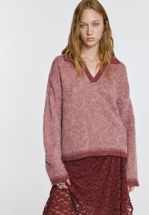 V-hals strikket sweater i gradient af rosa nuancer med en lodden tekstur, ribbede ærmegab og en krave. Kombineret med et blonderet bordeauxnederdel.