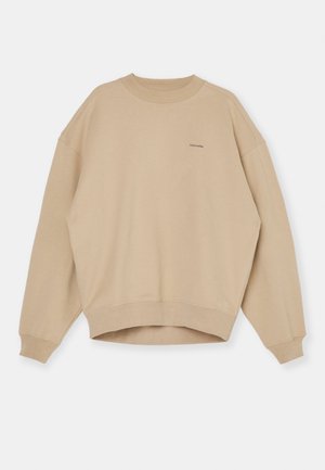 Beige sweatshirt i bomull, med rund hals, sänkt axel, vida ärmar och cropped fåll. Diskret logotyp på bröstet.