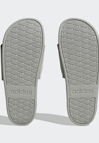 I sandali di gomma grigi presentano una suola a trama diamantata e un marchio "adidas". Il design include una larga fascia per il piede per un maggiore comfort.
