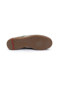 Suela de zapatilla de goma marrón con textura estampada. Presenta un acento rojo y ranuras para tracción. Diseño limpio y plano con bordes redondeados.
