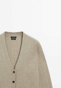 Cardigan beige clair à col en V avec deux boutons sur le devant, fabriqué en tissu 100 % cachemire.