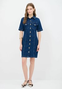 Denim-paitamekko lyhyillä hihoilla, napit edessä, rintataskut ja kontrastiväriset ompeleet. Tumma sininen väri ja klassinen malli.