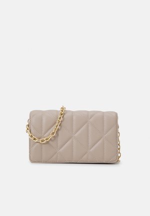 Pochette en cuir matelassé beige avec surpiqûres en losanges et une bandoulière chaîne dorée, posée sur un fond uni clair.