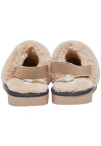 Karvaita vaaleita tossuja, joissa on pehmeä sisus, säädettävä joustovyö ja musta kumipohja; avonainen takaosa helpottaa pukemista.