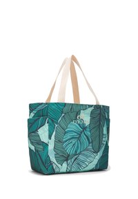 Taška typu tote s tyrkysovo-zeleným tropickým listovým vzorem, béžovými uchy a bočními kapsami, stojící vzpřímeně na bílém pozadí.