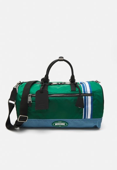 Green and blue nylon duffel bag with black hardware, dual handles, adjustable strap, zipper closure, white stripes, and logo accent.