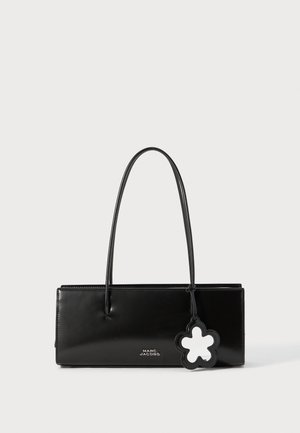 Geantă de piele neagră, cu formă rectangulară, două mânere lungi, logo marcat și un charm în formă de floare atașat. Textură netedă.