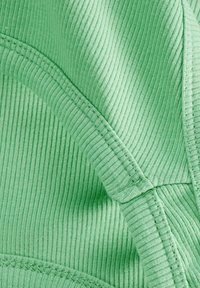 Ribbed fabric in light green with visible stitching. Smooth texture with slight sheen. Curved edges and seam details are prominent.