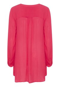 Blusa rosa a maniche lunghe realizzata in tessuto leggero e trasparente. La parte posteriore presenta dettagli arricciati e un collo rotondo.