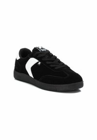 Zapatillas de ante negras con un acento de cuero blanco, suela texturizada, punta redonda y cordones negros. Presenta una marca en la lengüeta.