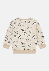 Beige sweatshirt med et leken trykk av hunder som står på skøyter og lekne tekster. Mykt stoff med ribbede mansjetter og kant.