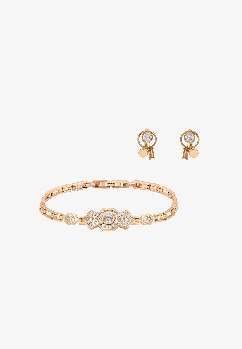 Złota bransoletka z geometrycznymi ogniwami i przezroczystymi kamieniami, w zestawie ze złotymi kolczykami wkrętami z okrągłymi przezroczystymi kamieniami i małymi zwisającymi zawieszkami.