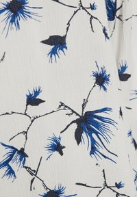 Tissu à motifs floraux avec des fleurs bleues et des tiges noires sur un fond blanc texturé, présentant un design imprimé intégral.