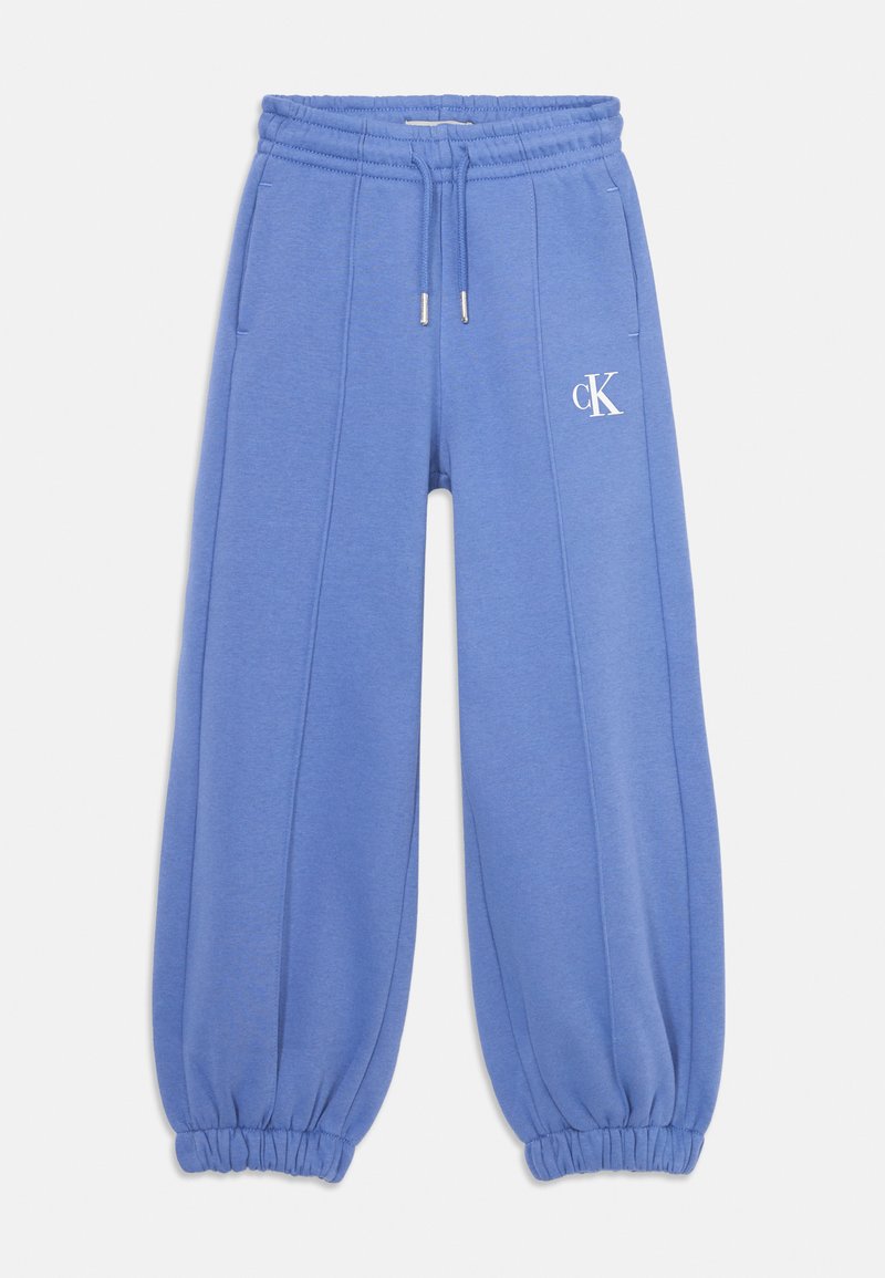 Pantaloni da tuta blu realizzati in tessuto morbido, con una vita elastica e coulisse, due tasche laterali e un logo bianco sulla gamba sinistra.