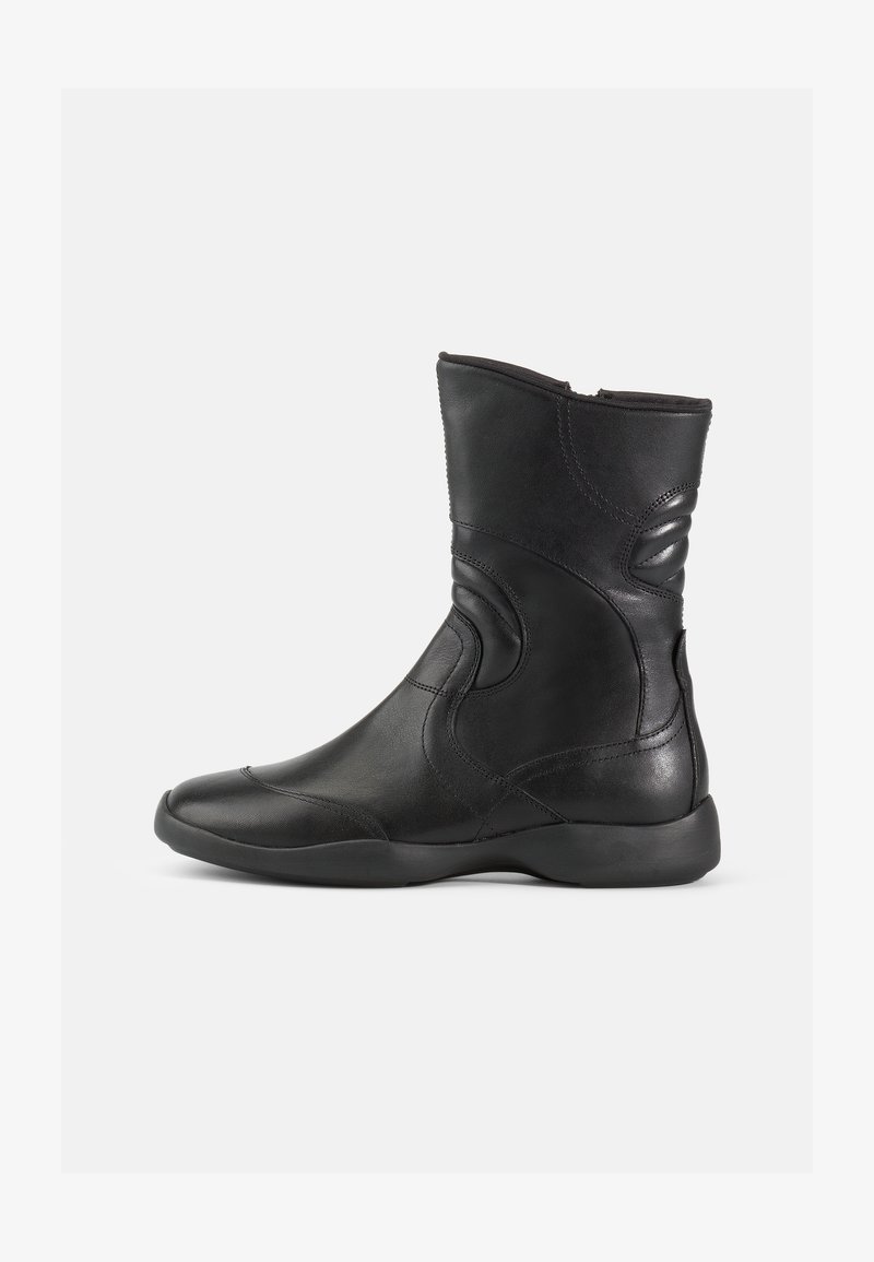 Bottines noires en cuir avec une finition lisse, dotées d'un bout arrondi, d'un col rembourré et de subtils détails de couture courbés.