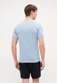 Light blue short-sleeve t-shirt made of soft fabric, featuring a round neckline. The back shows a simple design without patterns or accents.