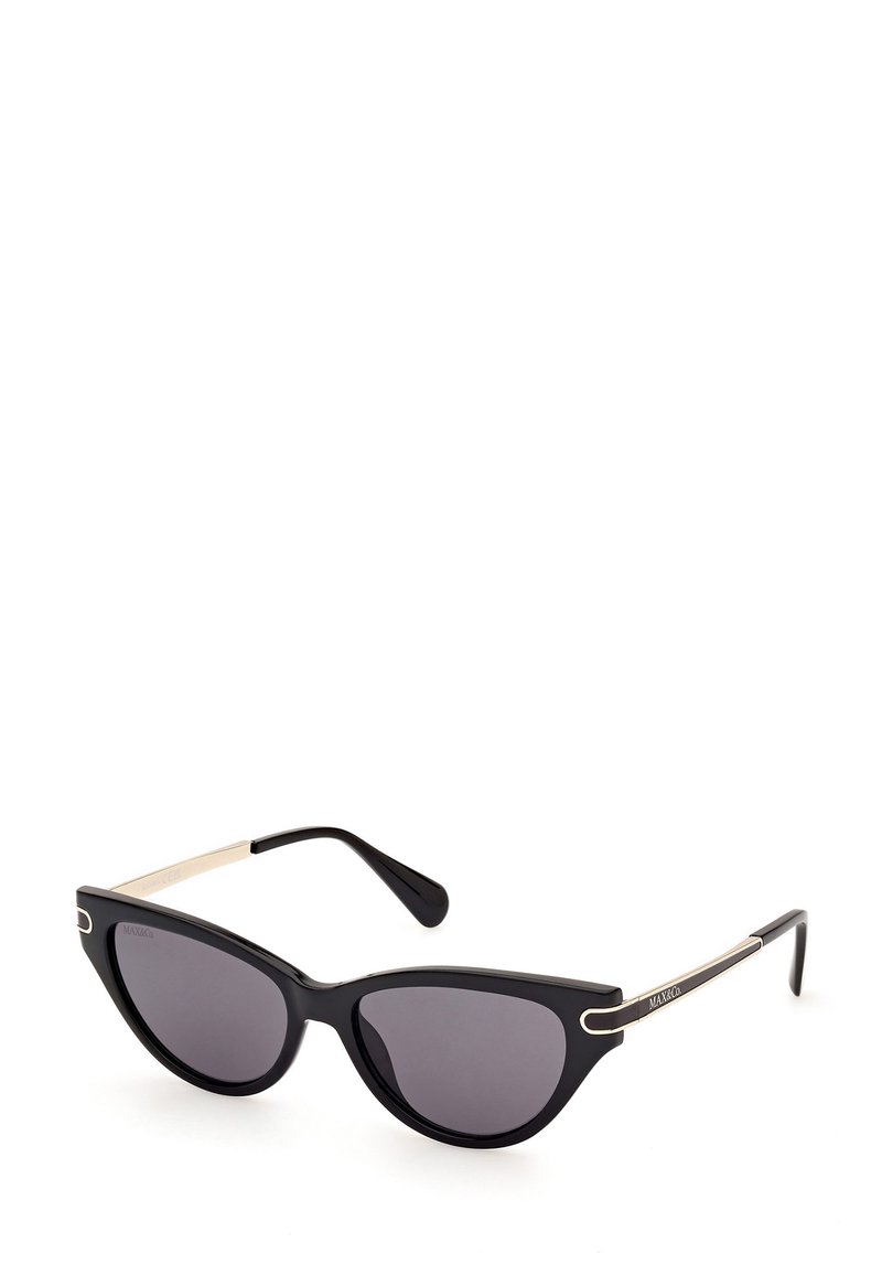 Gafas de sol estilo ojo de gato con montura negra, lentes grises y acentos metálicos en las varillas. Presentan un acabado brillante y brazos curvados.