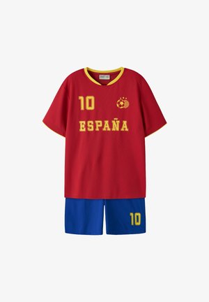 Piros focimez sárga szegéllyel, "10" és "España" felirattal, labda logóval, kék rövidnadrággal, melyen sárga "10" felirat található.
