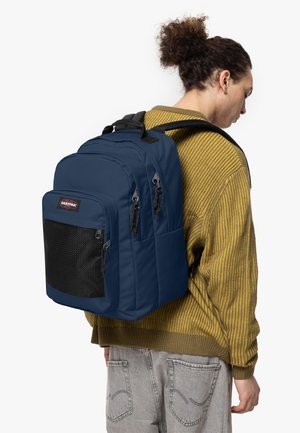 Zaino blu navy con più scomparti, spallacci imbottiti, parte anteriore in rete nera testurizzata e cerniere per una chiusura sicura.