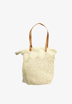 Sac tote en crochet de couleur crème avec des motifs circulaires et des anses en cuir marron, doté d'une fermeture éclair.