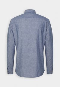 Camicia a maniche lunghe in morbido tessuto chambray azzurro, con colletto e polsini abbottonati, retro semplice e texture delicata.