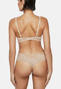 Kant beha en slipset in nude kleur, met ingewikkelde bloemenpatronen, verstelbare bandjes en zachte, gestructureerde stof voor comfort.