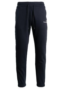 Mörkblå joggers i mjukt tyg, med en elastisk midja med dragsko, muddade fållar och en vit logotypdetalj på benet.