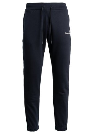 Tamsiai mėlynos sportinės kelnės, pagamintos iš minkštos medžiagos, su elastinga juosta ir raišteliais, su sutrauktomis apačiomis ir balta logotipo detale ant kojos.