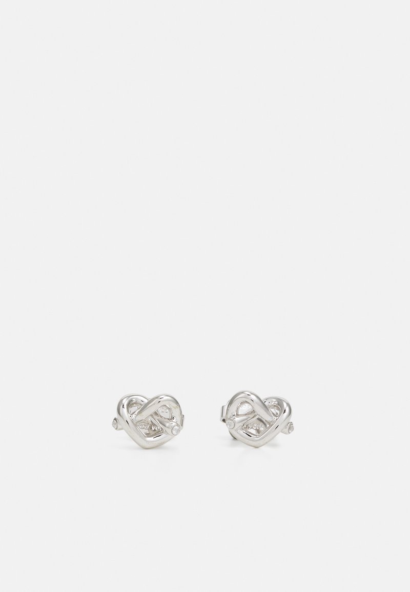 Silver stud earrings featuring an intertwined knot design with small clear accents, smooth surface with polished finish, and sleek metallic texture.