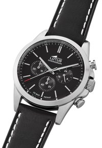 Reloj cronógrafo negro con caja de acero inoxidable, esfera negra con marcadores de hora plateados y correa de cuero negro con costuras blancas.