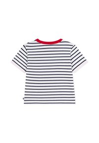 Κοντομάνικο λευκό μπλουζάκι με ναυτικές ρίγες. Διαθέτει κόκκινο γιακά και αντίθετες μανσέτες στα μανίκια, κατασκευασμένο από μαλακό ύφασμα.