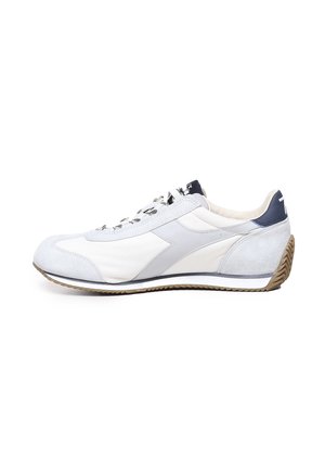 Scarpa atletica leggera in grigio e bianco con tomaia in camoscio e tessuto, suola in gomma e lacci a motivo. Presenta un design a profilo basso.