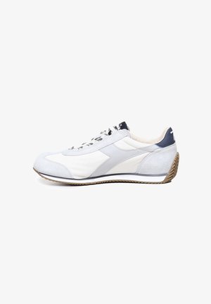 Scarpa atletica leggera in grigio e bianco con tomaia in camoscio e tessuto, suola in gomma e lacci a motivo. Presenta un design a profilo basso.