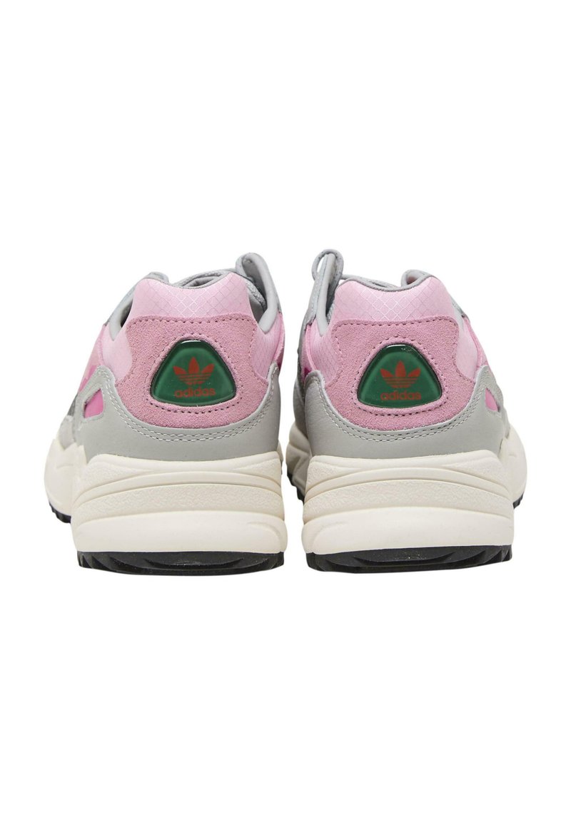 Scarpe sportive rosa e grigie realizzate in mesh e camoscio, con accenti del logo verde e suola testurizzata. Vista posteriore, senza lacci visibili.