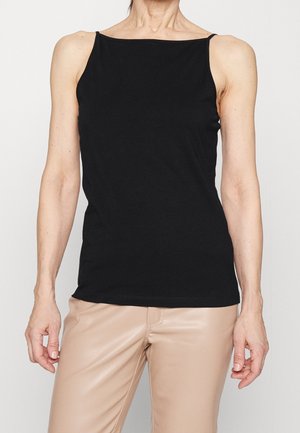 Zwart mouwloos topje in een aansluitend ontwerp, gemaakt van gladde stof. Heeft een vierkante halslijn en een minimalistische stijl. Gecombineerd met beige broek.