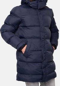 Marineblauer Steppmantel mit hohem Kragen, vertikalen Steppungen, zwei Seitentaschen und einem Frontreißverschluss. Der Stoff wirkt glatt und glänzend.