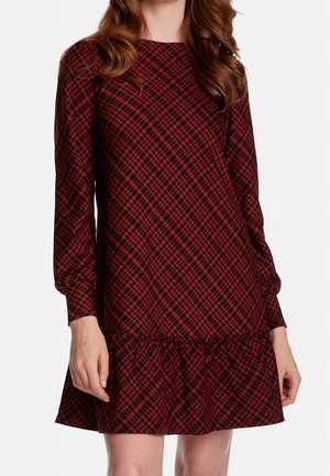 Robe à carreaux rouge et noire avec manches longues, encolure ronde et ourlet à volants. Confectionnée en tissu texturé. Coupe décontractée.